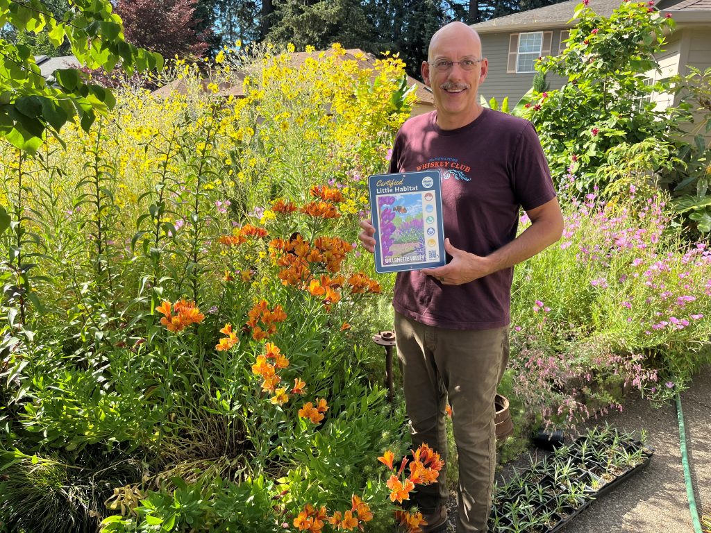 man holding certification sign in garden