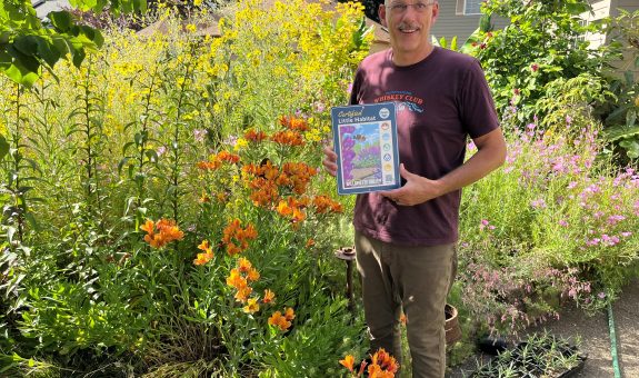 man holding certification sign in garden