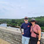 Kurt and Giselle pose with a river and riparian area behind them