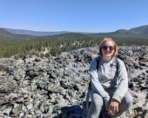 Marissa Theve sits on a rock that's part of a big obsidian flow. 